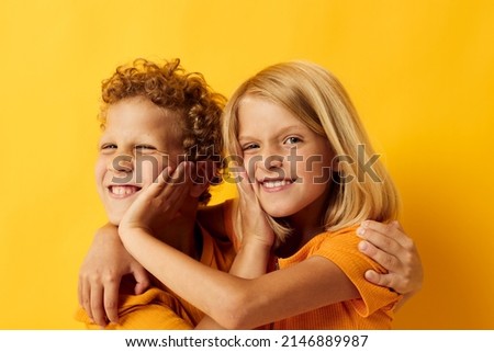 picture of positive boy and girl cuddling fashion childhood entertainment on colored background