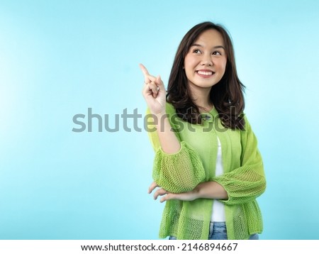 A happy Indonesian (Asian) girl caught an idea on a blue isolated background Royalty-Free Stock Photo #2146894667