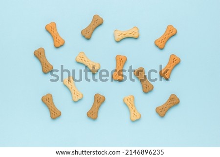 Dog biscuits scattered on a blue background. A delicious treat for dogs with cereals. Flat lay. Royalty-Free Stock Photo #2146896235
