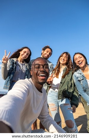 Smiling multiracial friends take selfie looking at camera. Copy space. Vertical image.