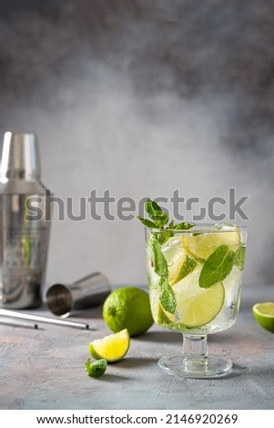 Mojito cocktail. Glass of cold mohito beverage with lime, leaves of mint, bar accessories on dark grey background with copy space for text. Cocktail bar Weekend or holiday party, menu, recipe Royalty-Free Stock Photo #2146920269