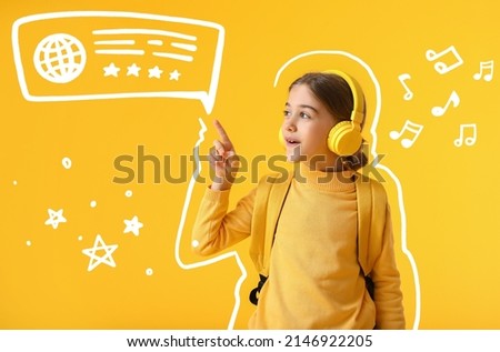 Cute little schoolgirl with headphones and different drawings on yellow background