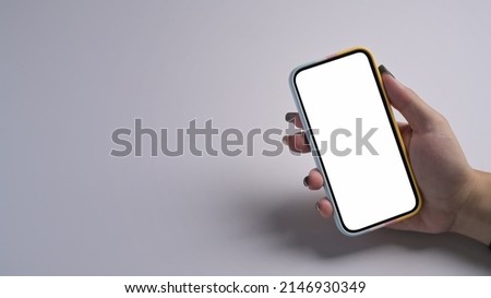 Close up view woman hand holding mobile phone with empty screen isolated on white background.