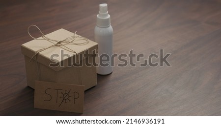 eco friendly paper gift box on walnut table with stop coronavirus paper card, wide photo