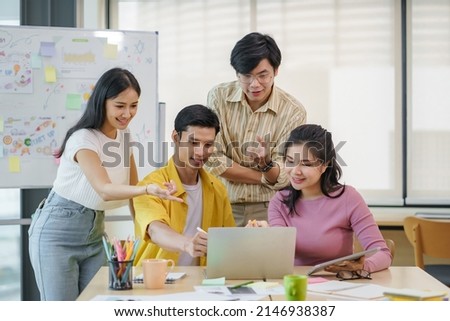 Group of young Asian business people brainstorming, looking at laptop computer. Royalty-Free Stock Photo #2146938387
