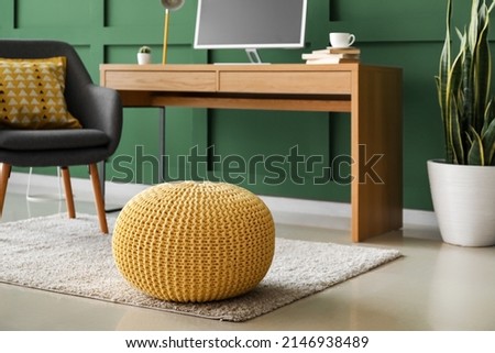 Comfortable ottoman on floor in room with modern workplace Royalty-Free Stock Photo #2146938489