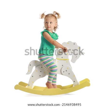 Adorable baby girl with rocking horse on white background Royalty-Free Stock Photo #2146938495