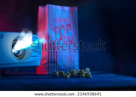 Concept of relaxing and watching movies. Projector and popcorn. Banner for design. Home cinema.