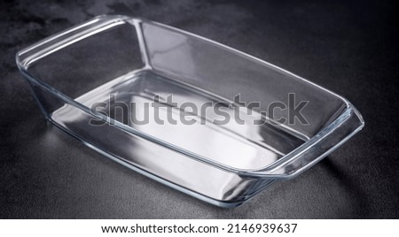 A rectangular glass empty dish for baking on a dark concrete background. Preparation for baking tasty cupcake