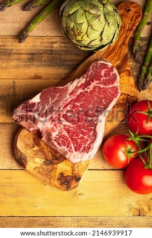 Juicy fresh piece of marbled beef steak with vegetables for grilling. Culinary background, recipe book, taste food, Steak cooking. With space, vertical photo