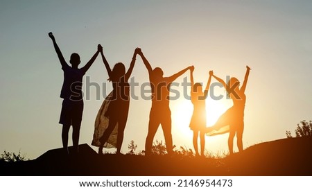 happy family parents holding hands raised their hands up. dad mom daughter and son are dream happy in park. family friendly kid dream concept, sunlight