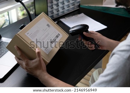 Male seller online store worker holding scanner scanning parcel bar code packing e-commerce post shipping box preparing online retail shop order in drop shipping delivery service warehouse. Royalty-Free Stock Photo #2146956949