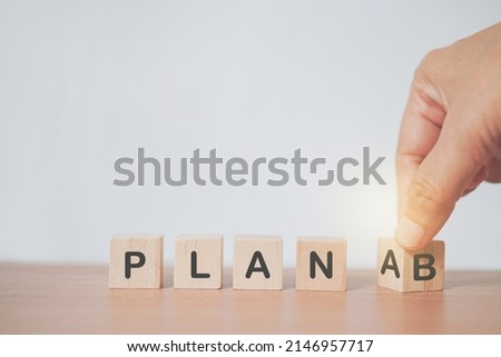  senior's hand turned cube and changing the word 'Plan A' to 'Plan B' with copy space for business strategy concept,  choosing or changing plan  in a person's life