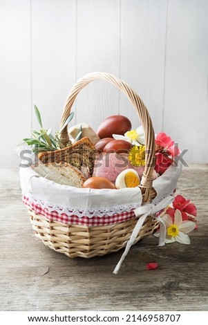 Easter traditional food with ham, eggs and bread in basket. Holidays background. Easter basket filled with all sorts of delicious delicatessen ready for an Easter meal. Royalty-Free Stock Photo #2146958707