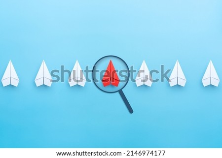 Red paper plane with magnifying glass icon, blue background