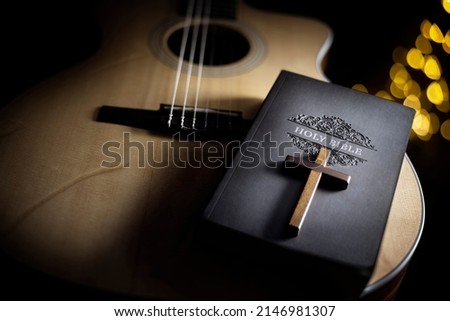 Holy Bible with acoustic guitar and religious crucifix cross, gospel music concept Royalty-Free Stock Photo #2146981307