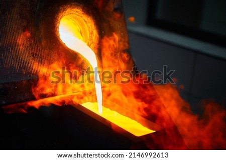Pouring liquid gold into graphite casting form from furnace Royalty-Free Stock Photo #2146992613