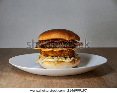Huge burger with meat and cheese on wooden background