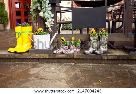 colorful family rain boots with flowers on a rainy day outdoors, horizontal, 