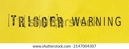 Trigger warning sign message on yellow background. Stamp letters mental triggering concept. Royalty-Free Stock Photo #2147004307