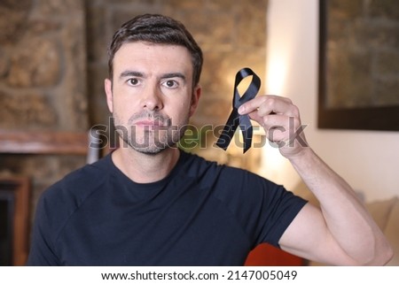 Man holding a black ribbon