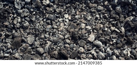 A background of scattered charcoal. Burning coal. Smoldering coal.  Royalty-Free Stock Photo #2147009385