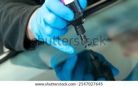 mechanic is repairing an stone chip using his glass repair equipment Royalty-Free Stock Photo #2147027645