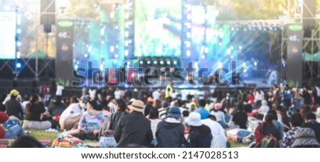 Blurred people watching concert in the park at open air,Summer festival concert.Light from the stage. Royalty-Free Stock Photo #2147028513