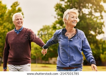 Love keeps a marriage alive. Shot of a happy senior couple going for a walk in the park. Royalty-Free Stock Photo #2147031785
