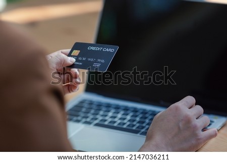 Closeup Asian woman using credit card with laptop for online in office, technology money wallet and online payment concept, credit card mockup