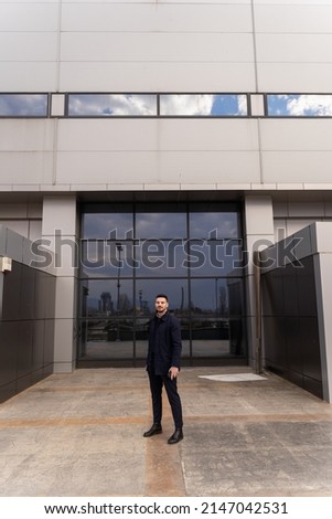 Attrctive and handsome businessman is posing in front of the company Royalty-Free Stock Photo #2147042531