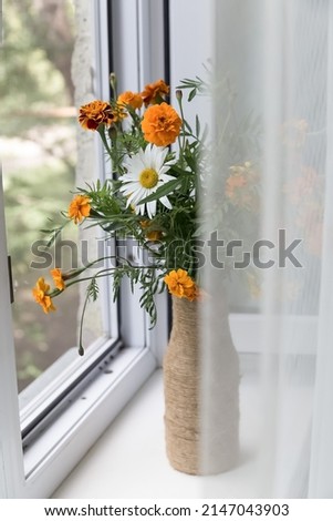 Bright summer flowers in a vase on the window decorate the house, lifestyle, comfort