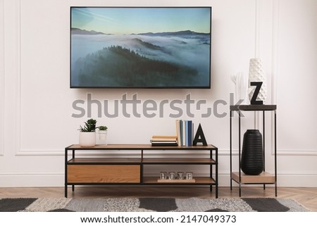 Stylish room interior with modern TV, cabinet and decorative elements Royalty-Free Stock Photo #2147049373