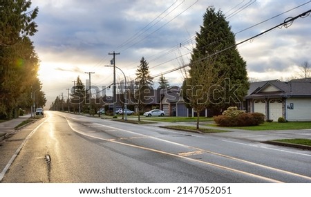 Fraser Heights, Surrey, Greater Vancouver, BC, Canada. Street view in the Residential Neighborhood during a colorful spring season. Colorful Sunrise Sky. Royalty-Free Stock Photo #2147052051