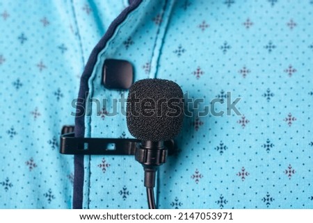 Close-up of a microphone attached to a shirt.