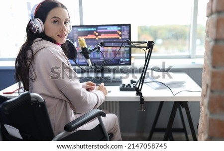 Disabled woman works as radio presenter in wheelchair in studio. Cybersport for disabled people concept