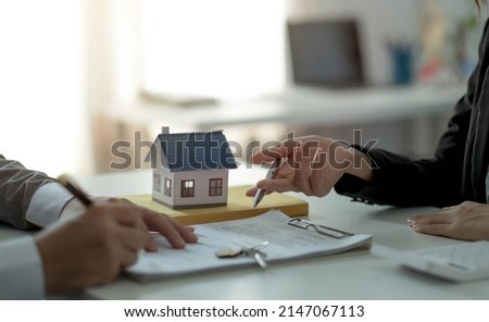 Real estate agent or sales manager has proposed terms and conditions to customers who sign house purchase agreements with insurance, Agreement to sign the purchase contract concept.
