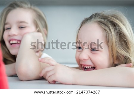 Two girls watching a fun video on the tablet close-up. Online Education concept. Portrait of two children watching TV.