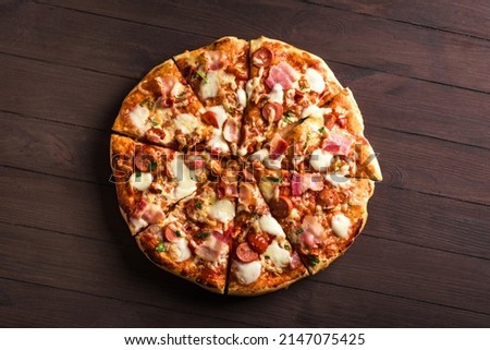 Bacon and Sausage Pizza with mozzarella cheese on wooden table. Homemade Meat Lovers Pizza, top view. Royalty-Free Stock Photo #2147075425