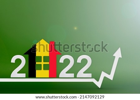 The cost of real estate in Belgium in 2022. Rising cost of construction, insurance, rent in Belgium. House model painted in the colors of the flag, up arrow on a green background