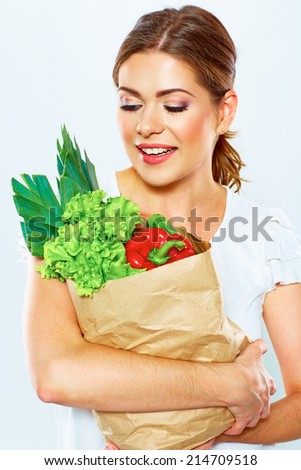 portrait of happy woman with green vegan food in paper bag. white background.