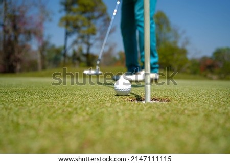 Golfer playing golf in the evening golf course, on sun set evening time. Man playing golf on a golf course in the sun.                               Royalty-Free Stock Photo #2147111115