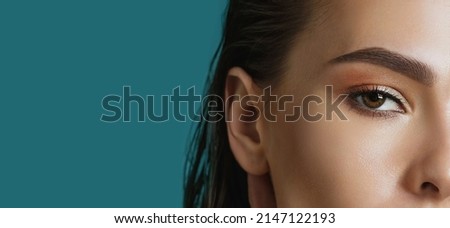 brunette female eyes. Vision control or visual acuity laser surgery concepts, close-up, blue background Royalty-Free Stock Photo #2147122193