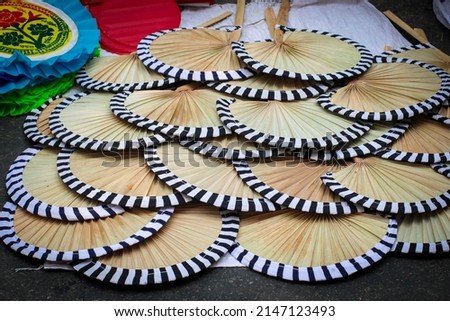 Artistic Hand Fan, Pakha, Air Blower or Bamboo Made Handicraft Fan with Handle Sold in Pahela Baishakh - Bangla New Year Royalty-Free Stock Photo #2147123493