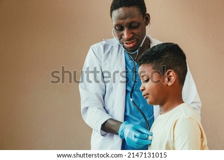 african american man pediatrician doctor using stethoscope to examining little boy from sickness in the office at the hospital. medical and healthy lifestyle concept.