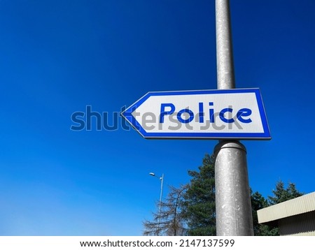 Blue pointer with word Police on pillar outdoors