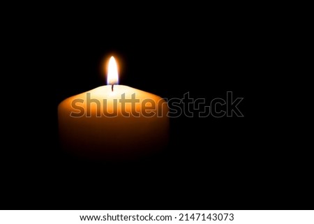 Memorial candle with flame in the dark