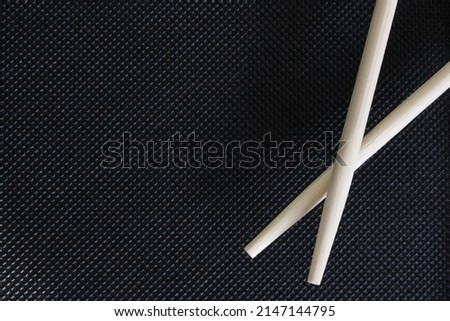 Sushi sticks on a black background with an empty space. The concept of food. Japanese cuisine. Background for websites, posters, postcards