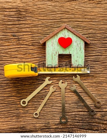 Wooden house with red heart and wrench put on the old wood, Loan for construction real estate and renovate the new home for family concept.