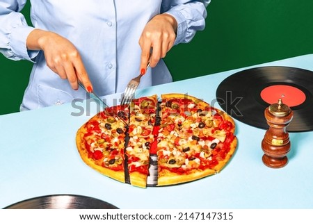 Tasting italian cuisine. Food pop art photography. Female hands with italian pizza lying on vinyl discs on light cloth isolated on green background. Vintage, retro style interior. Complementary colors